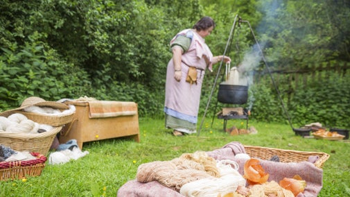 Baskets of woollen yarn and a woman in Roman dress with a caldron